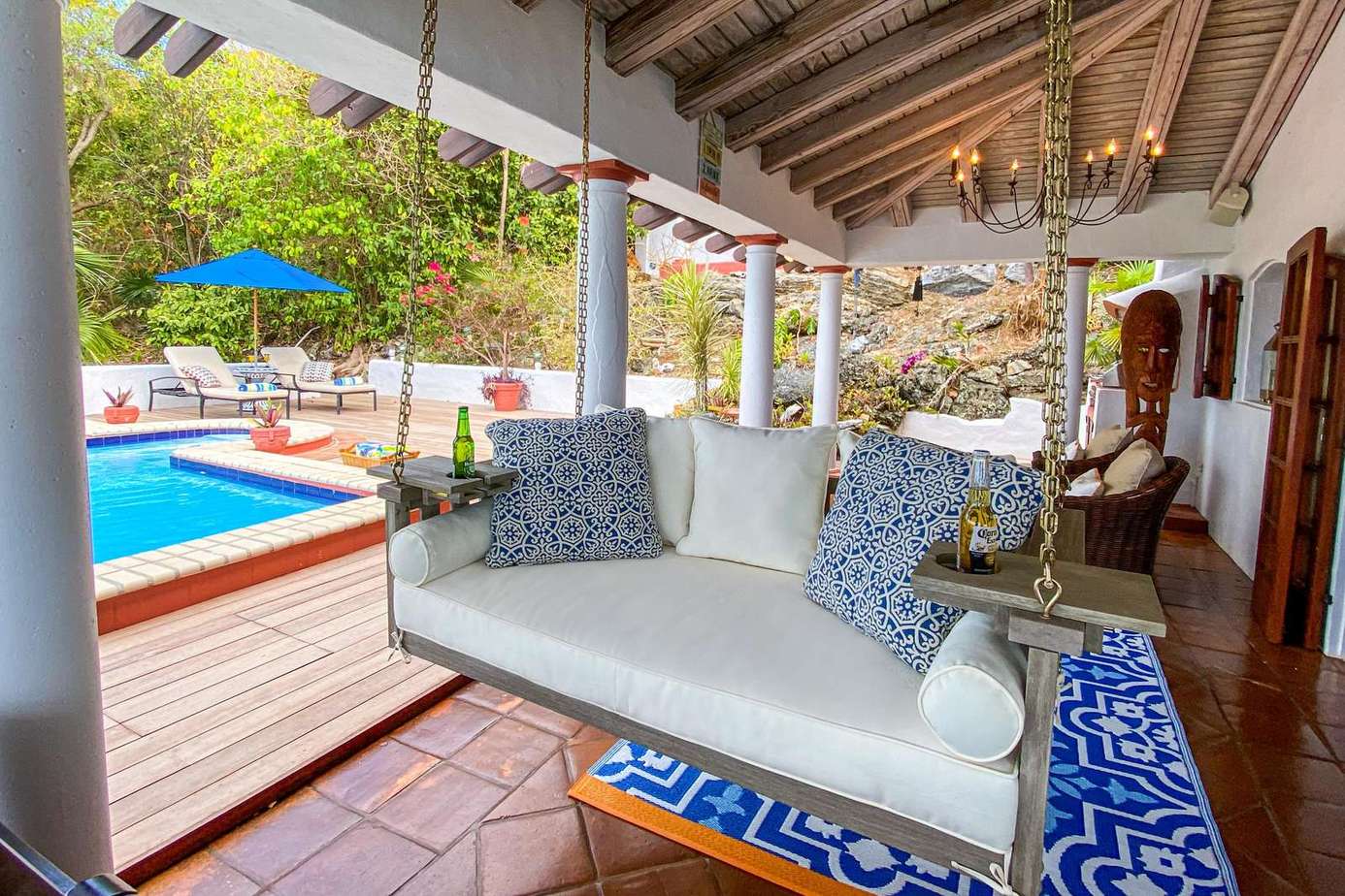 Charming covered patio with cozy seating and pool views
