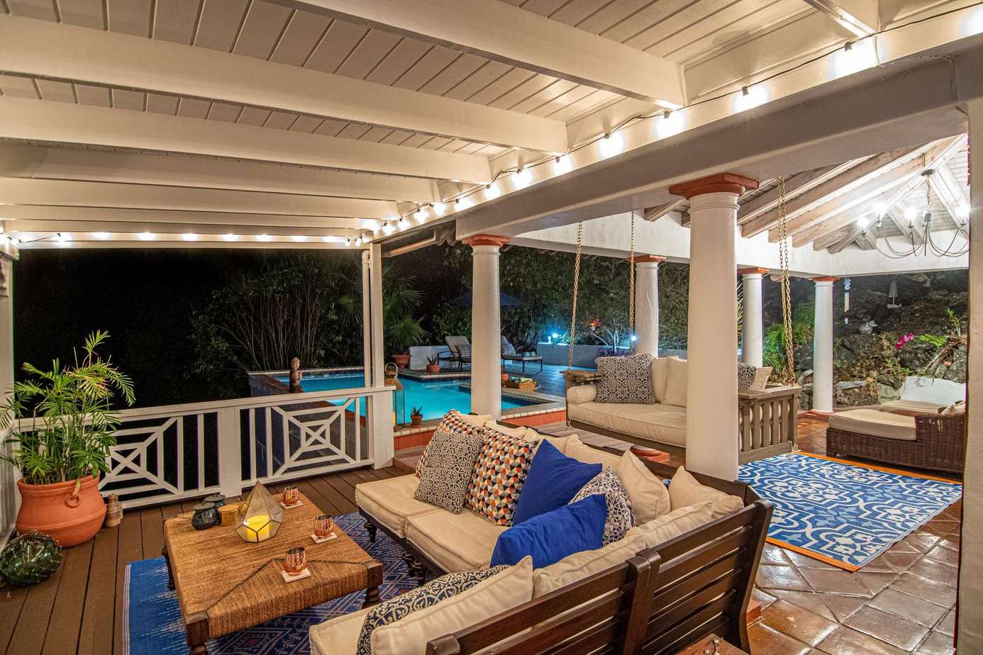 Cozy covered patio with plush seating and ambient lighting