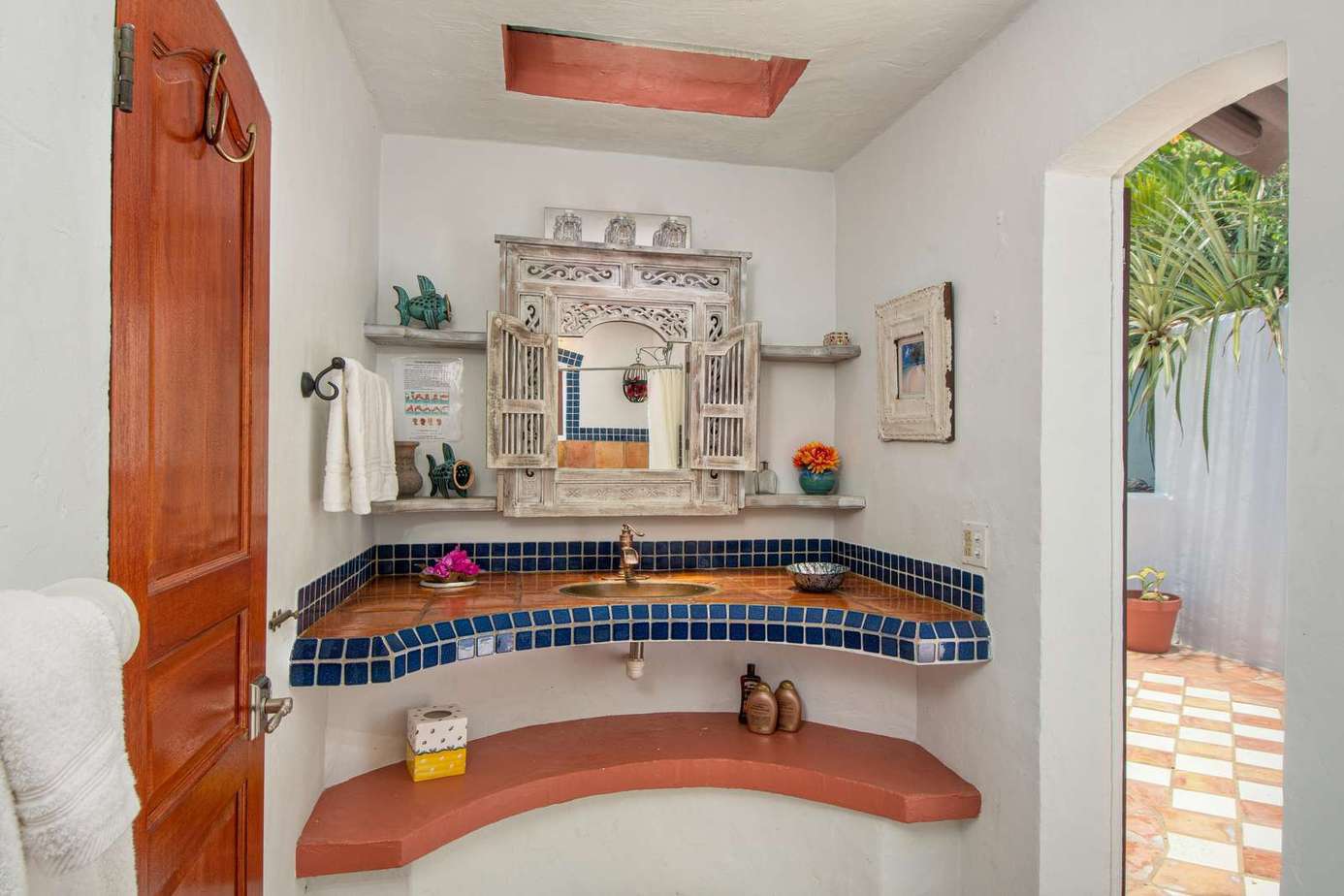 Charming outdoor sink area with vibrant tile accents and natural light