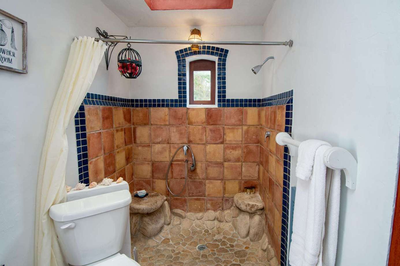 Cozy rustic bathroom with unique stone shower and warm tile accents