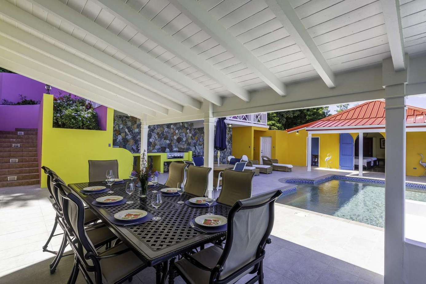 Shaded outdoor dining area overlooking sparkling private pool
