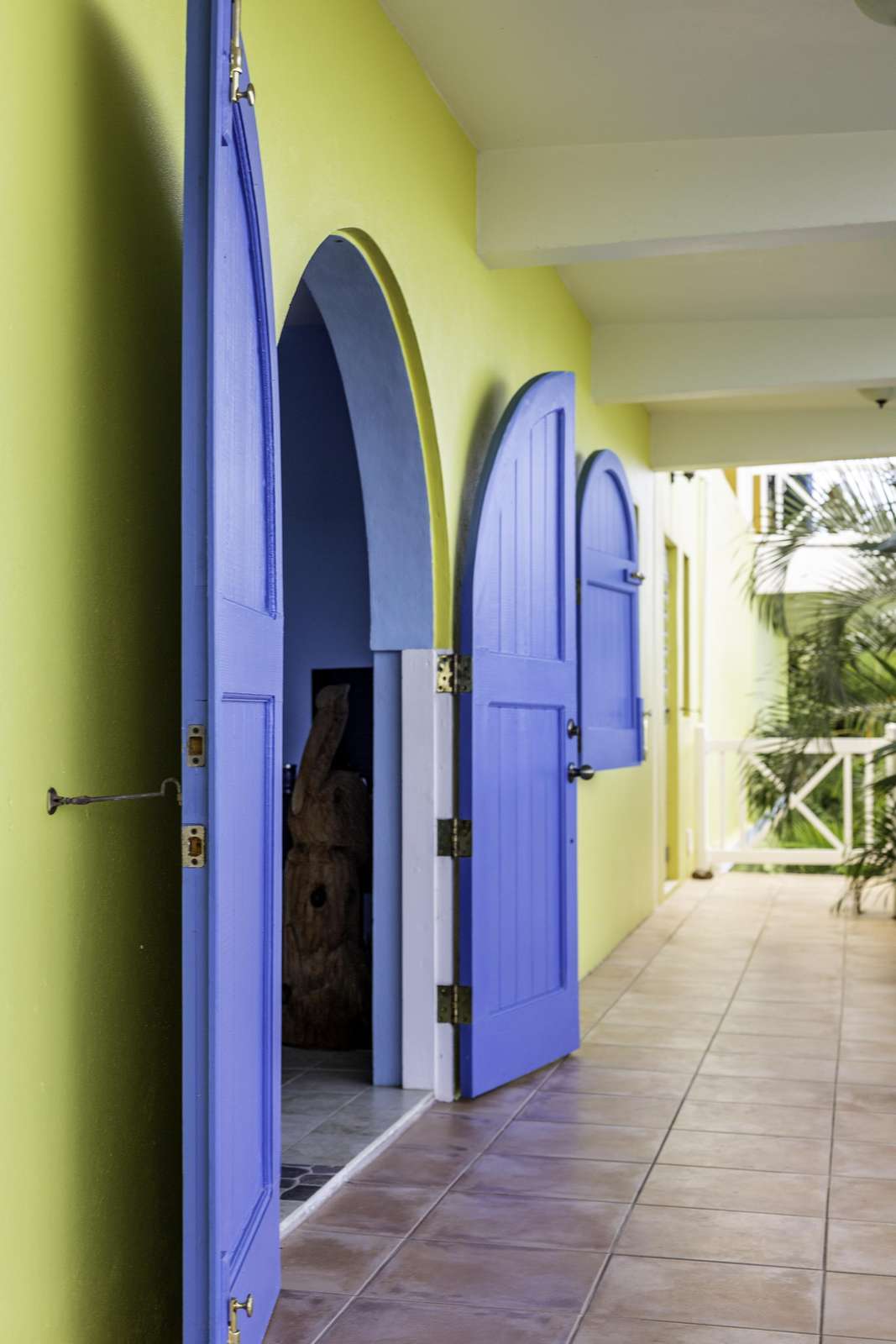 Sunlit hallway with vibrant arched doorways and tiled floor