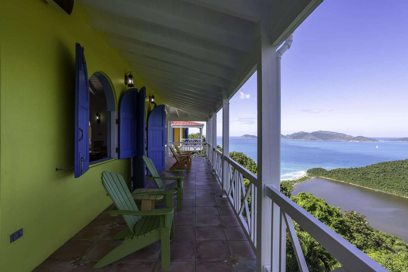Spacious covered balcony with panoramic ocean views and cozy seating