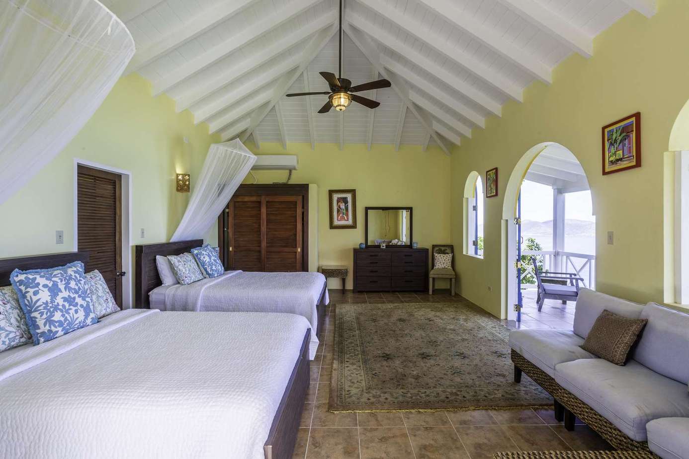 Spacious bedroom with vaulted ceilings and cozy seating area