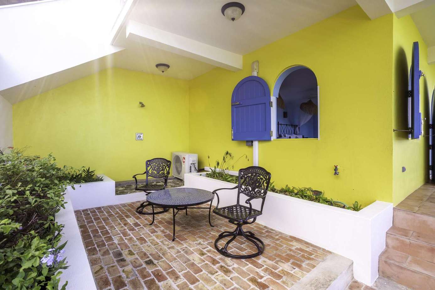 Sunny courtyard with vibrant walls and cozy seating area