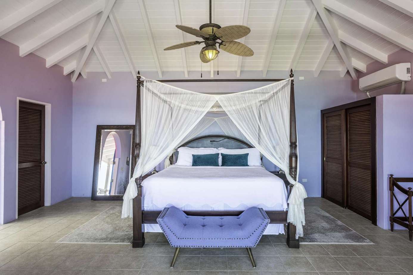 Spacious bedroom with vaulted ceilings and elegant canopy bed