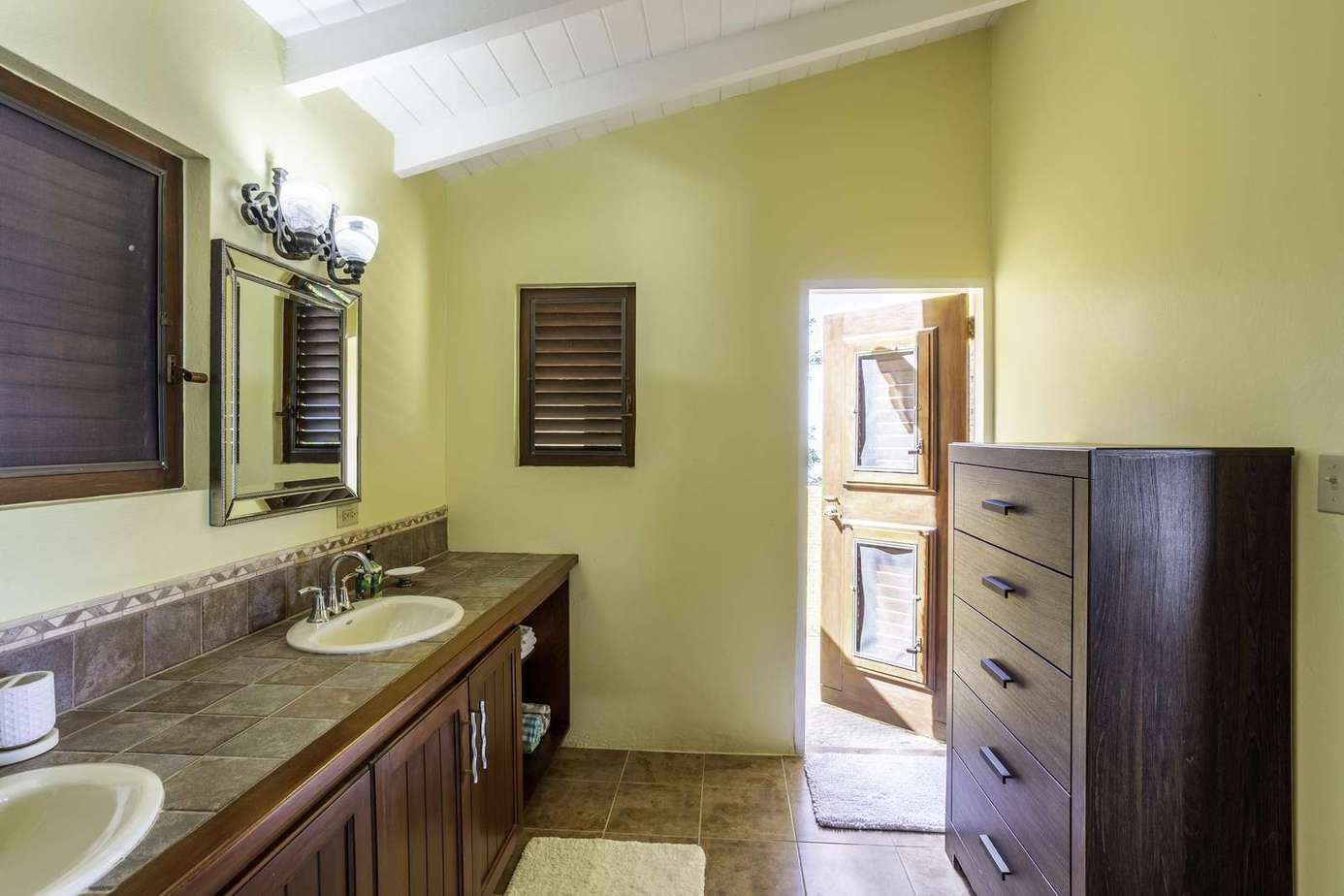 Spacious bathroom with dual sinks and warm lighting