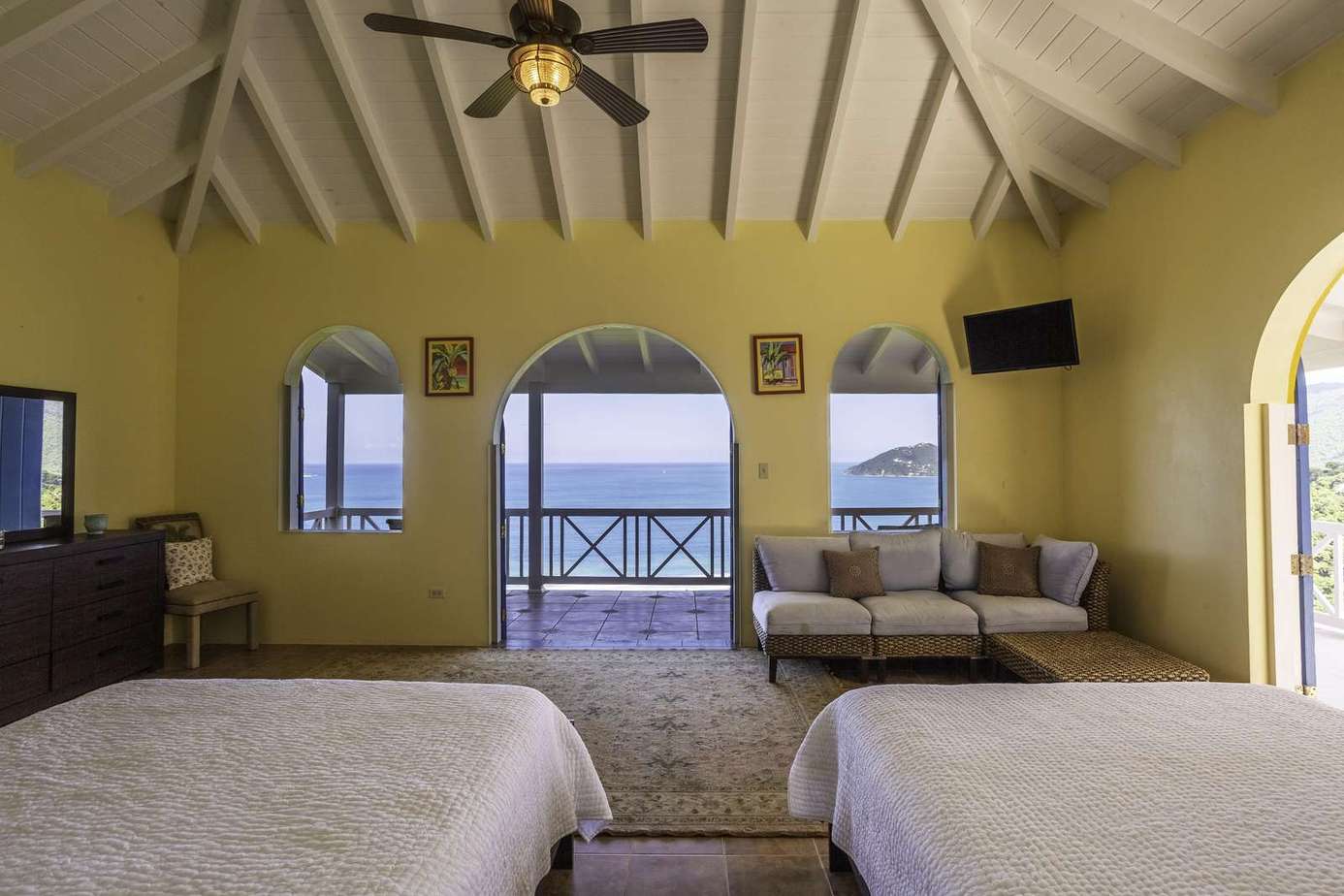 Spacious bedroom with ocean views and breezy balcony access