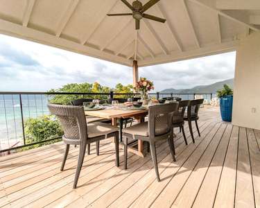 Spacious, covered outdoor dining for 8 with the kitchen adjacent and the sound of the waves just yards away