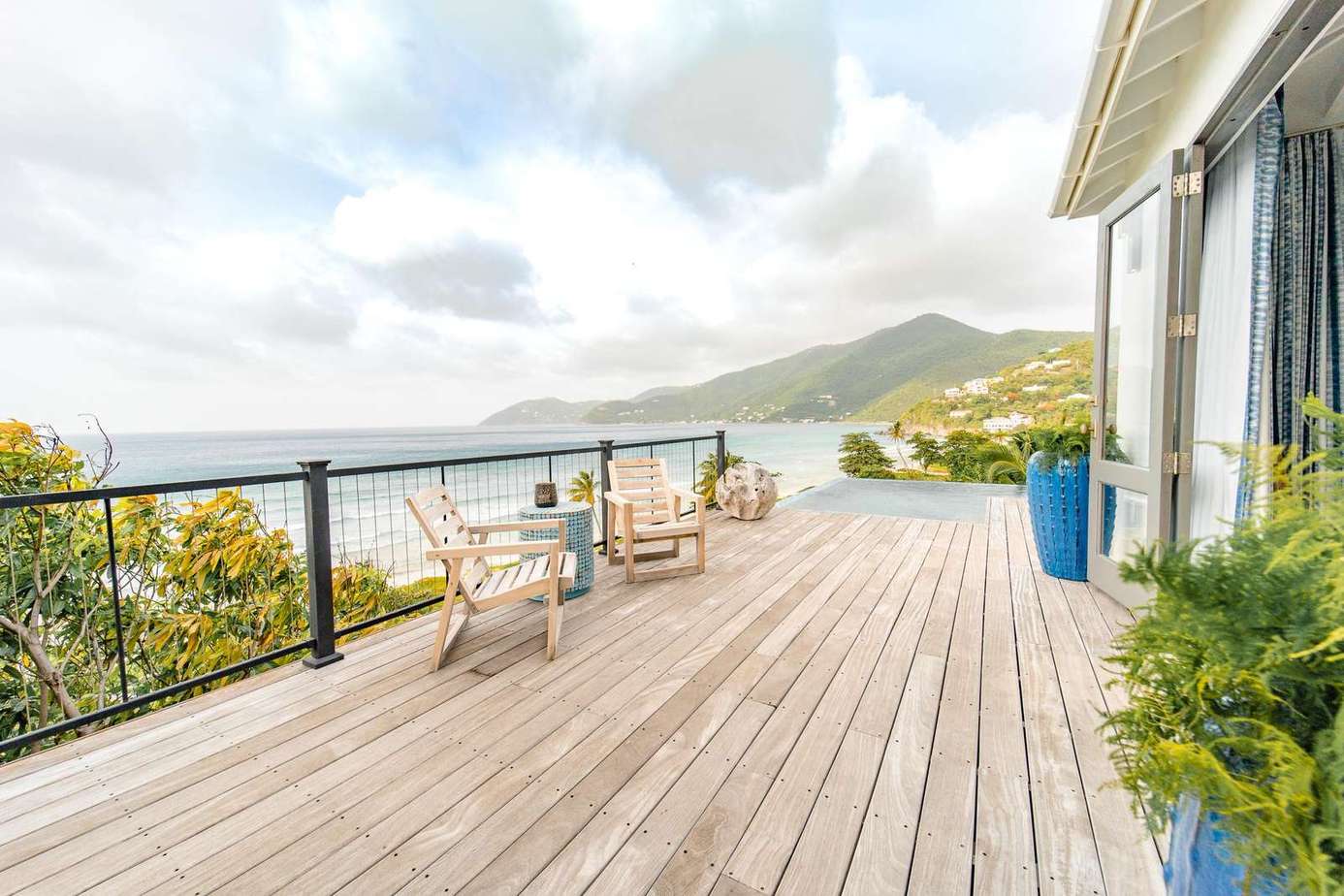 A wooden deck stretches the width of the property in front of the 2nd bedroom, kitchen and living room to the pool