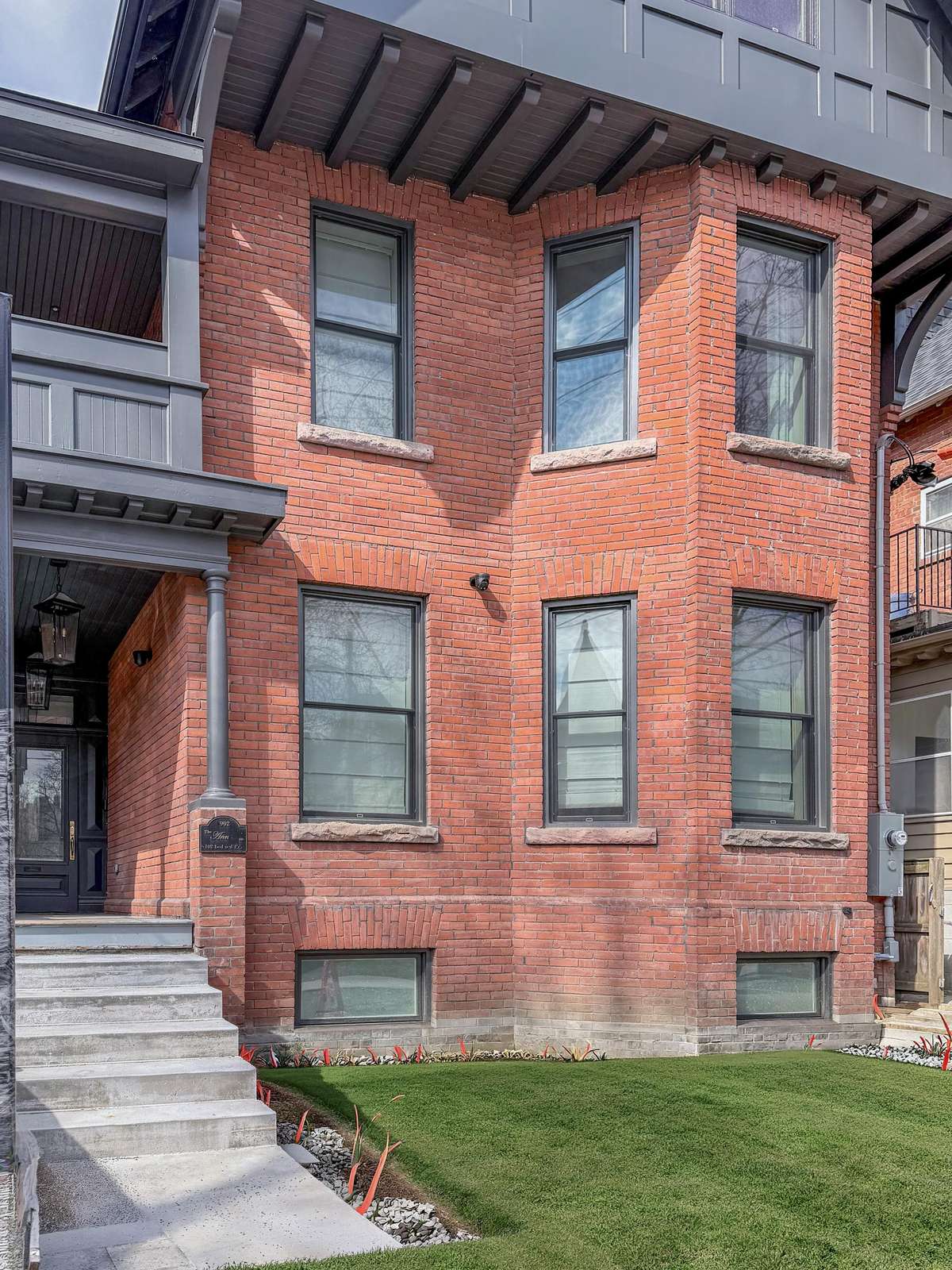 Charming brick exterior with classic city charm and green lawn