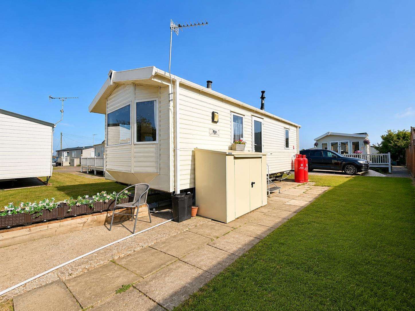 A clean, well-kept static caravan at California Cliffs Holiday Park, with bright blue skies and a lovely lawn to enjoy. Perfect for relaxed stays at one of the coast’s welcoming holiday parks. - property
