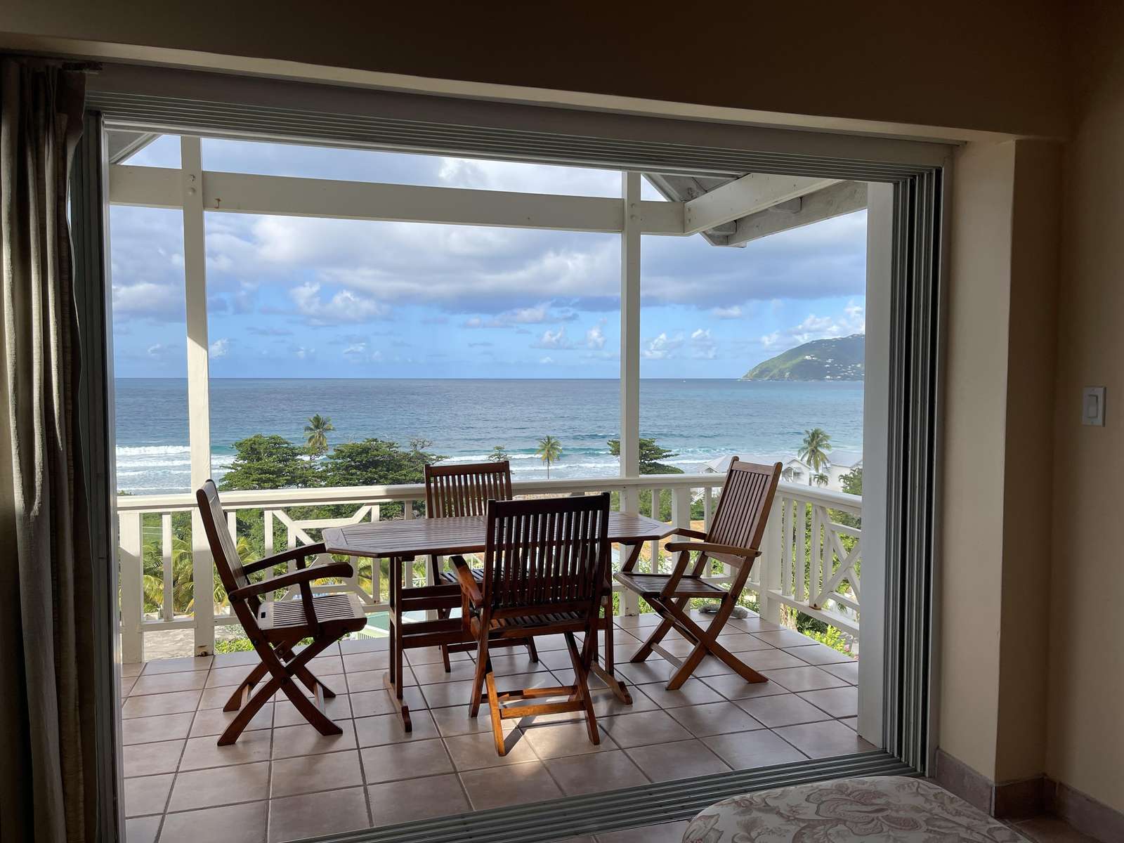 Ocean-view patio with cozy dining and sunset charm - property