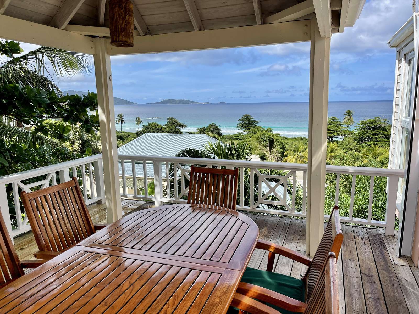 Ocean-view porch with cozy seating for sunset dinners - property