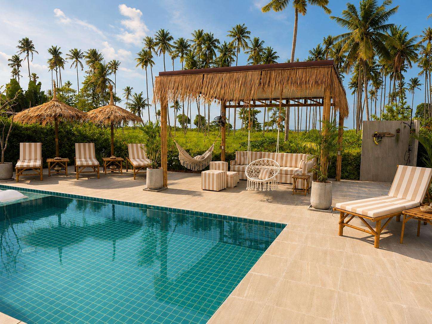 Swimming pool with turquoise tiles, bamboo lounge chairs, striped cushions, and a thatched pergola with hanging chair. - property