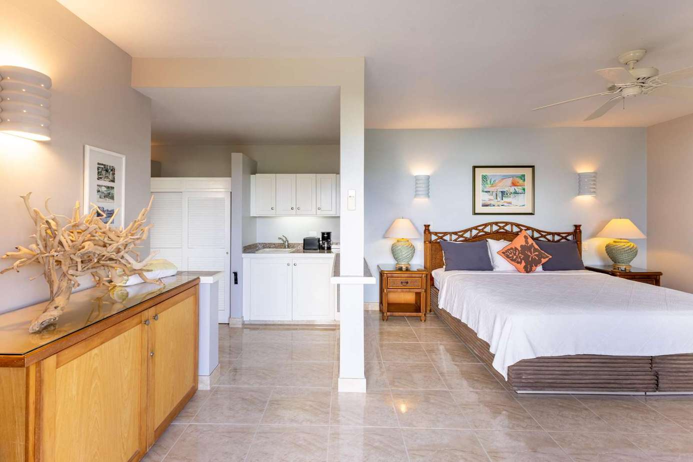 Spacious bedroom with cozy seating and bright kitchenette