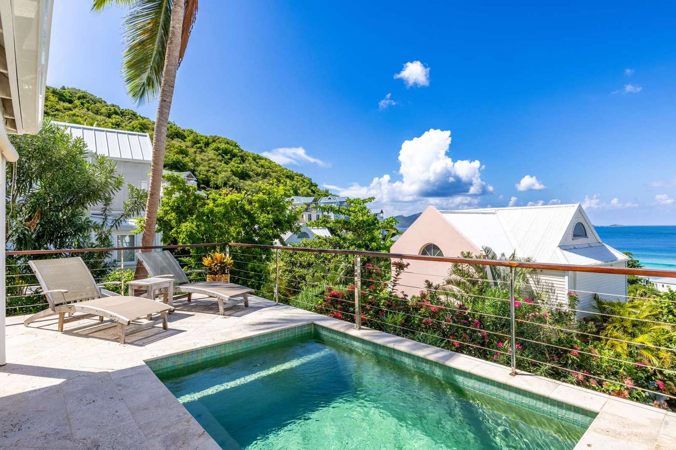 Secluded poolside retreat with ocean views and lounge chairs