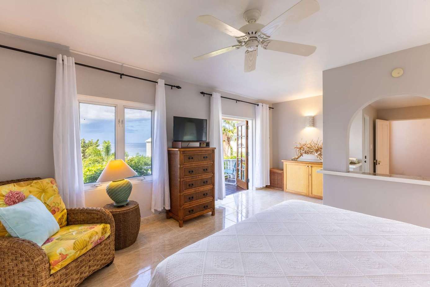 Bright and airy bedroom with ocean views and cozy seating