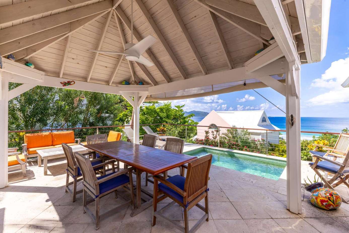 Shaded outdoor dining with pool and ocean views