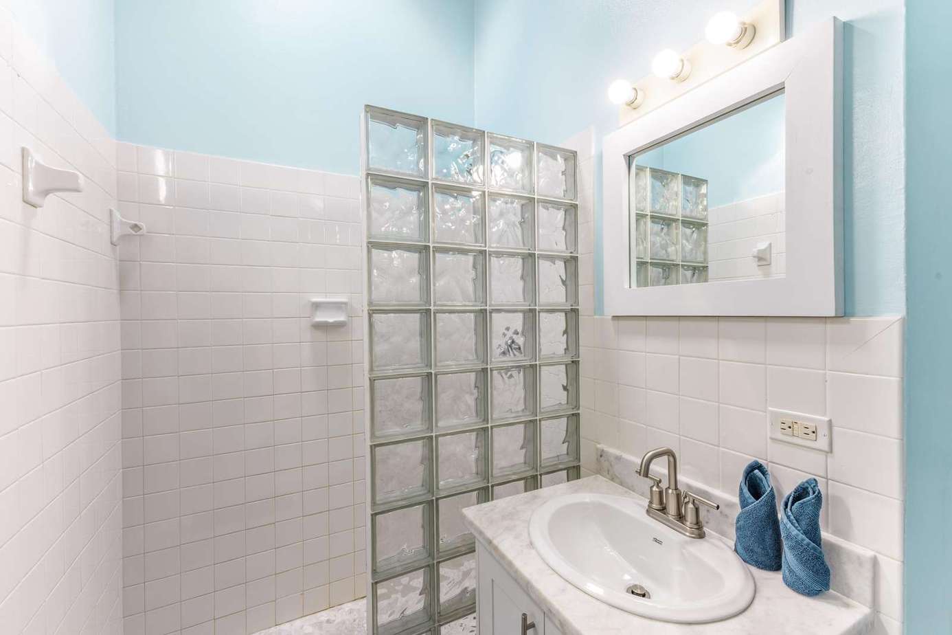 Bright, airy bathroom with modern glass block shower wall