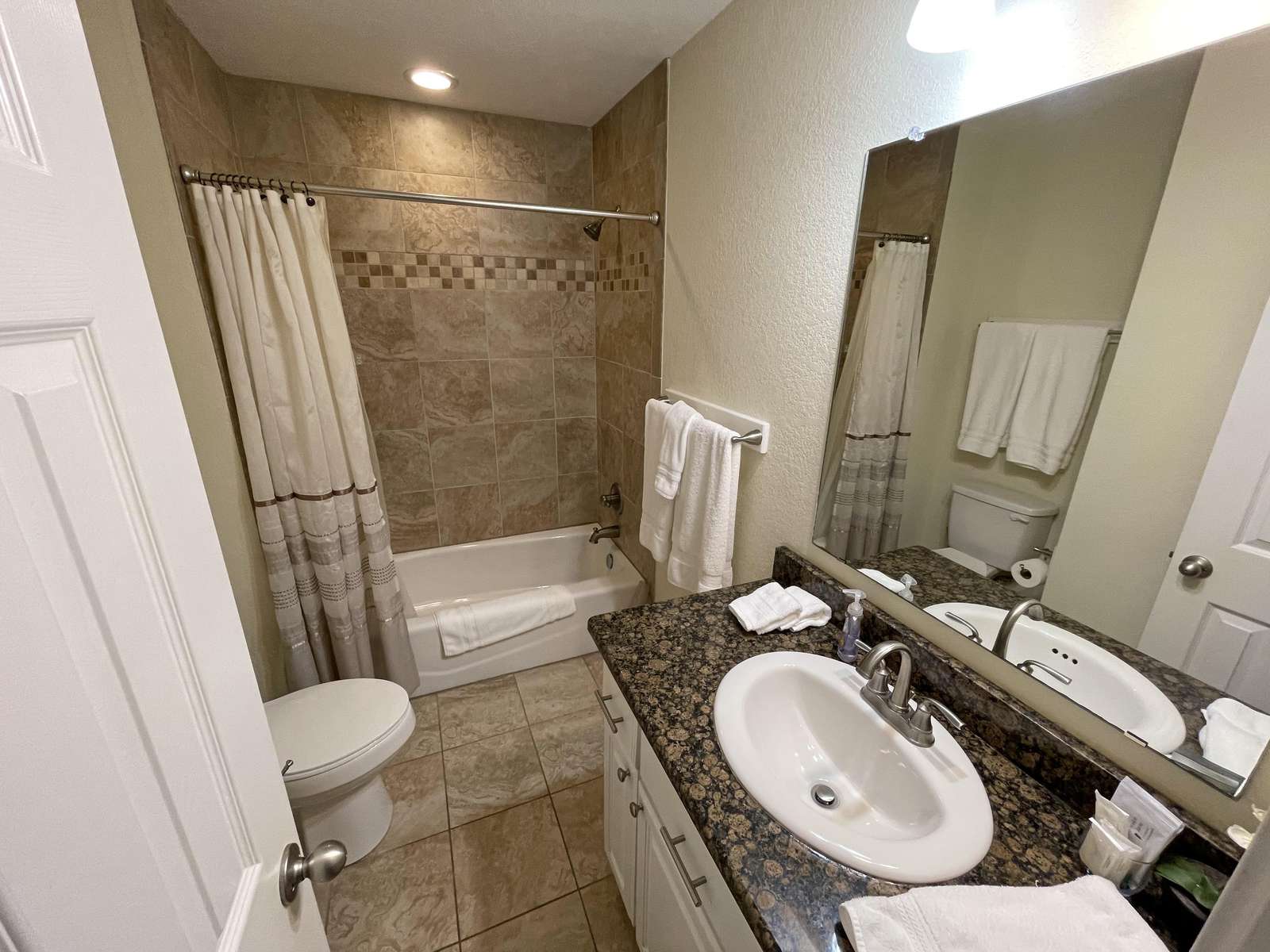 The upper level communal bathroom. All bathrooms are tiled with enamel tubs and granite counters throughout.