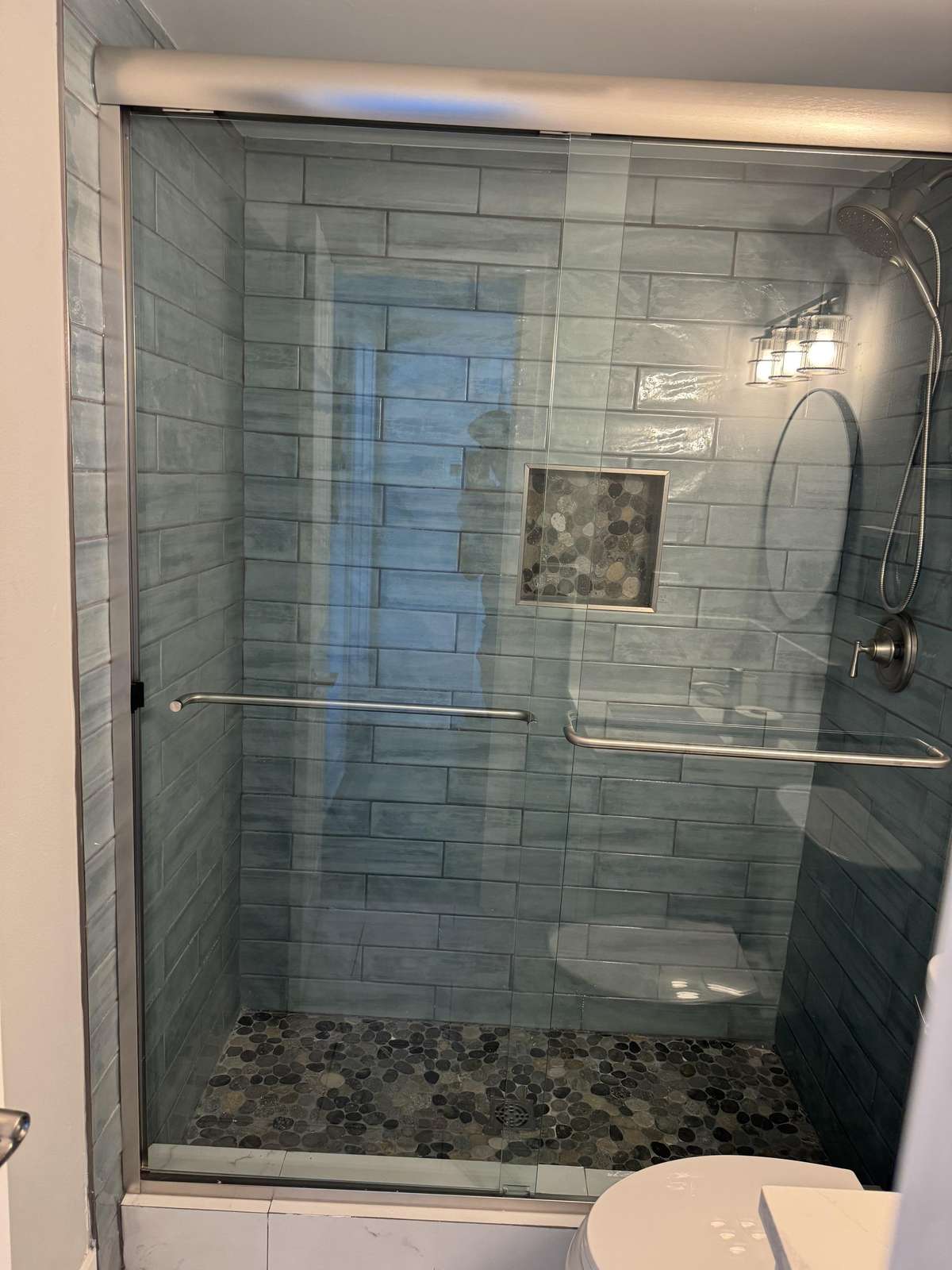 Guest bathroom with modern sleek glass-enclosed shower and stylish tile accents