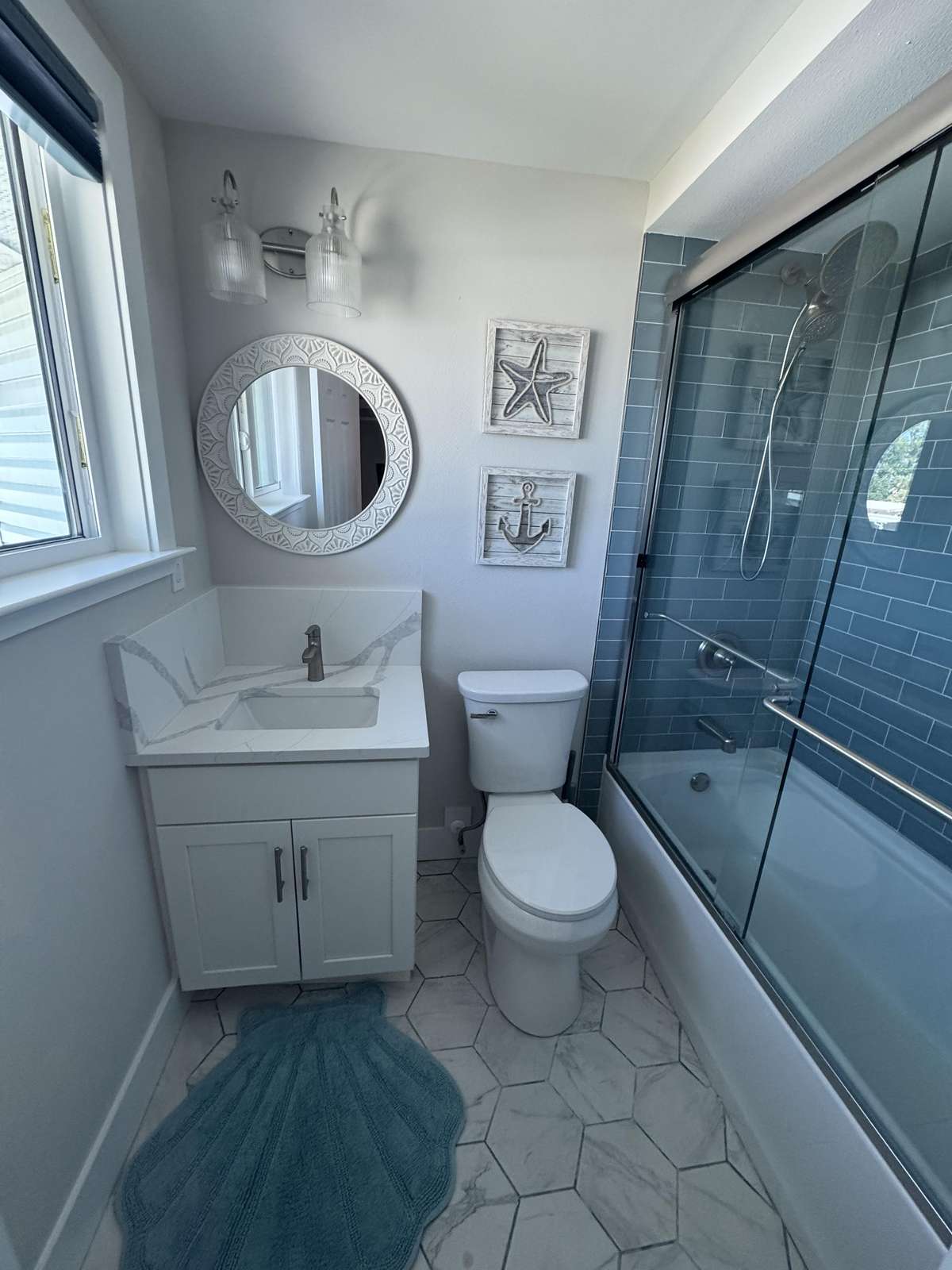 Master bathroom with sleek glass shower/tub and marble floors