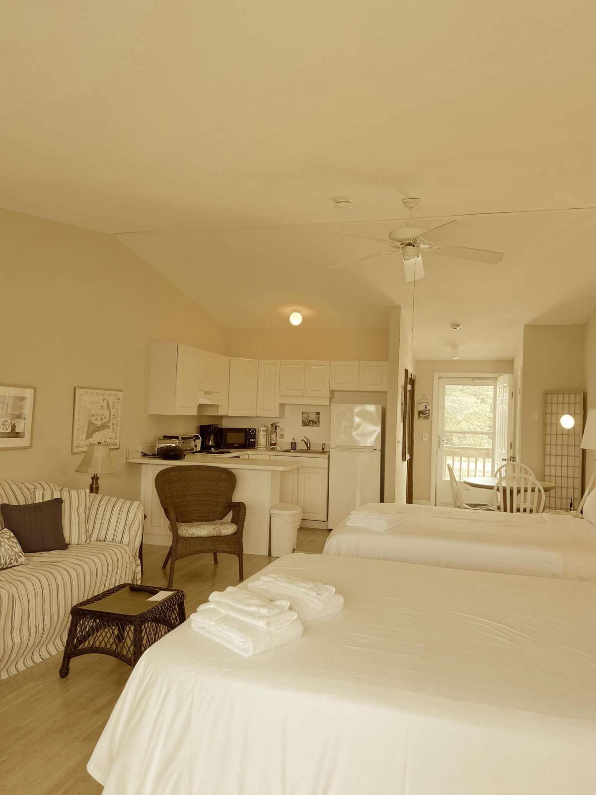 Bright and airy bedroom with cozy seating and open kitchen view - property