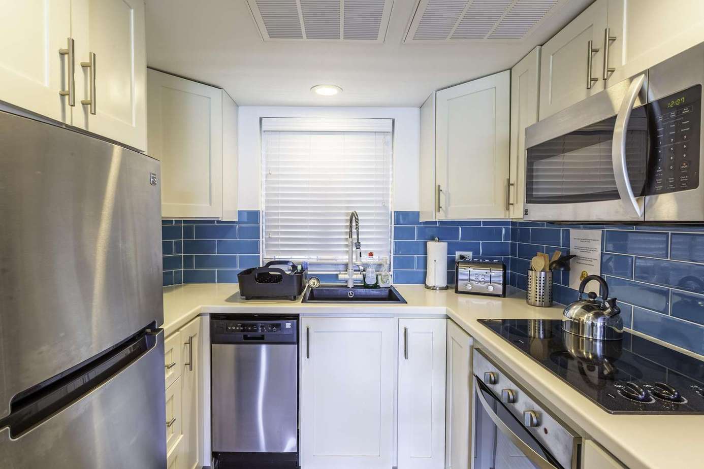 Bright kitchen with modern appliances and vibrant blue backsplash