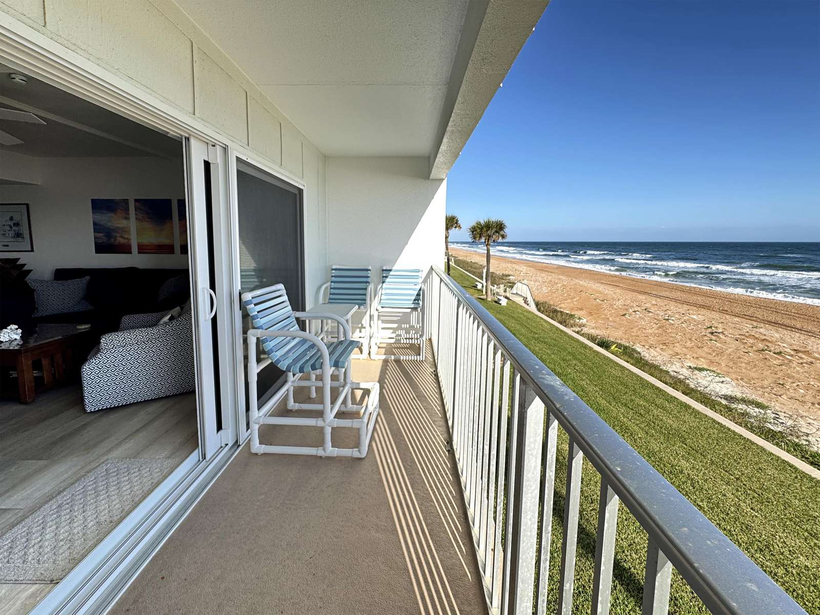 Oceanfront balcony with cozy seating and stunning views - property