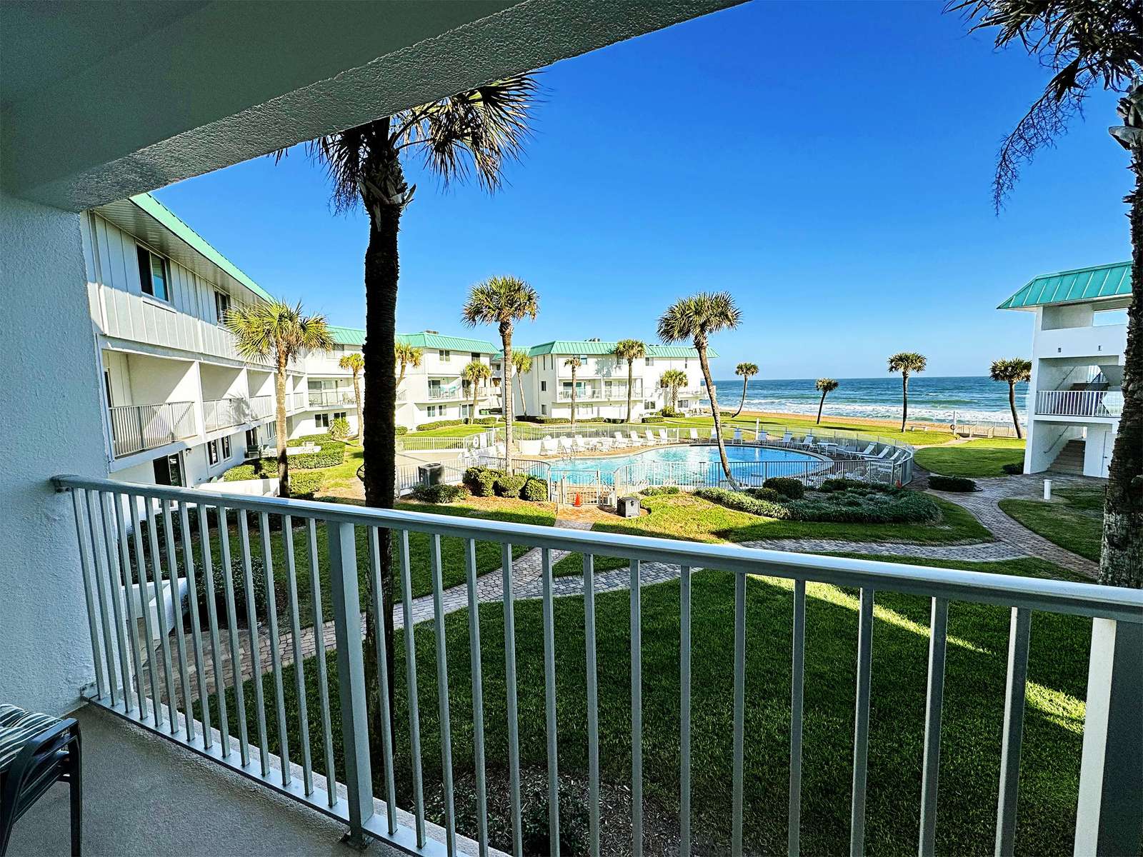 Balcony retreat overlooking serene waterfront and palm trees - property