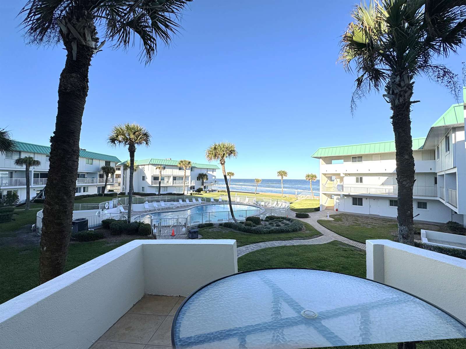 Cozy patio with pool and palm tree views for relaxing days - property