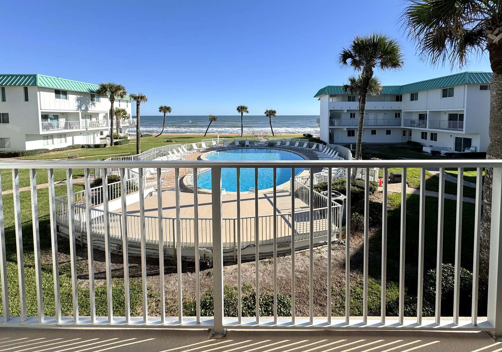 Balcony view overlooking pool and ocean beyond - property