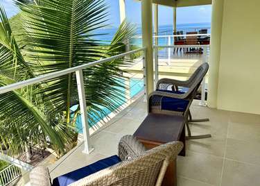 Relax on the sunny balcony with ocean views and cozy seating