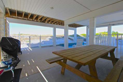 Covered pool deck with picnic table and gas/charcoal grills