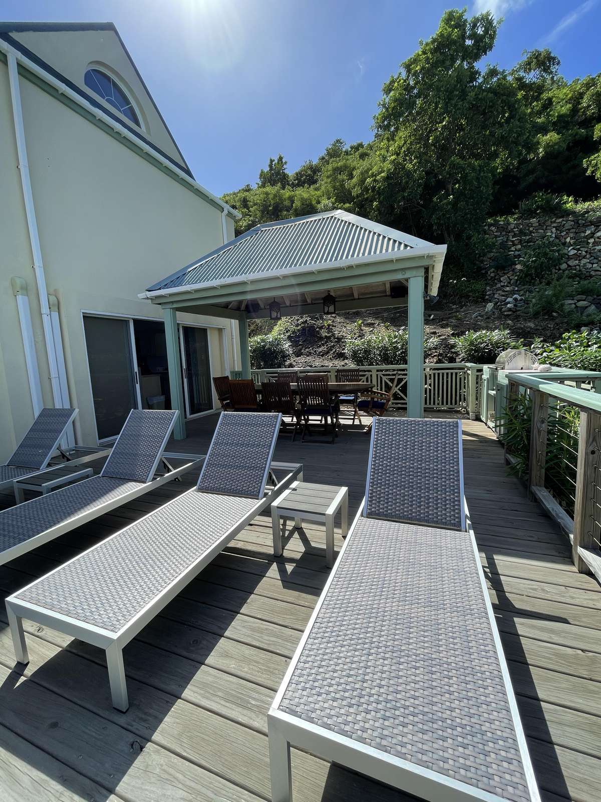 Sun-soaked patio with loungers and shaded dining area