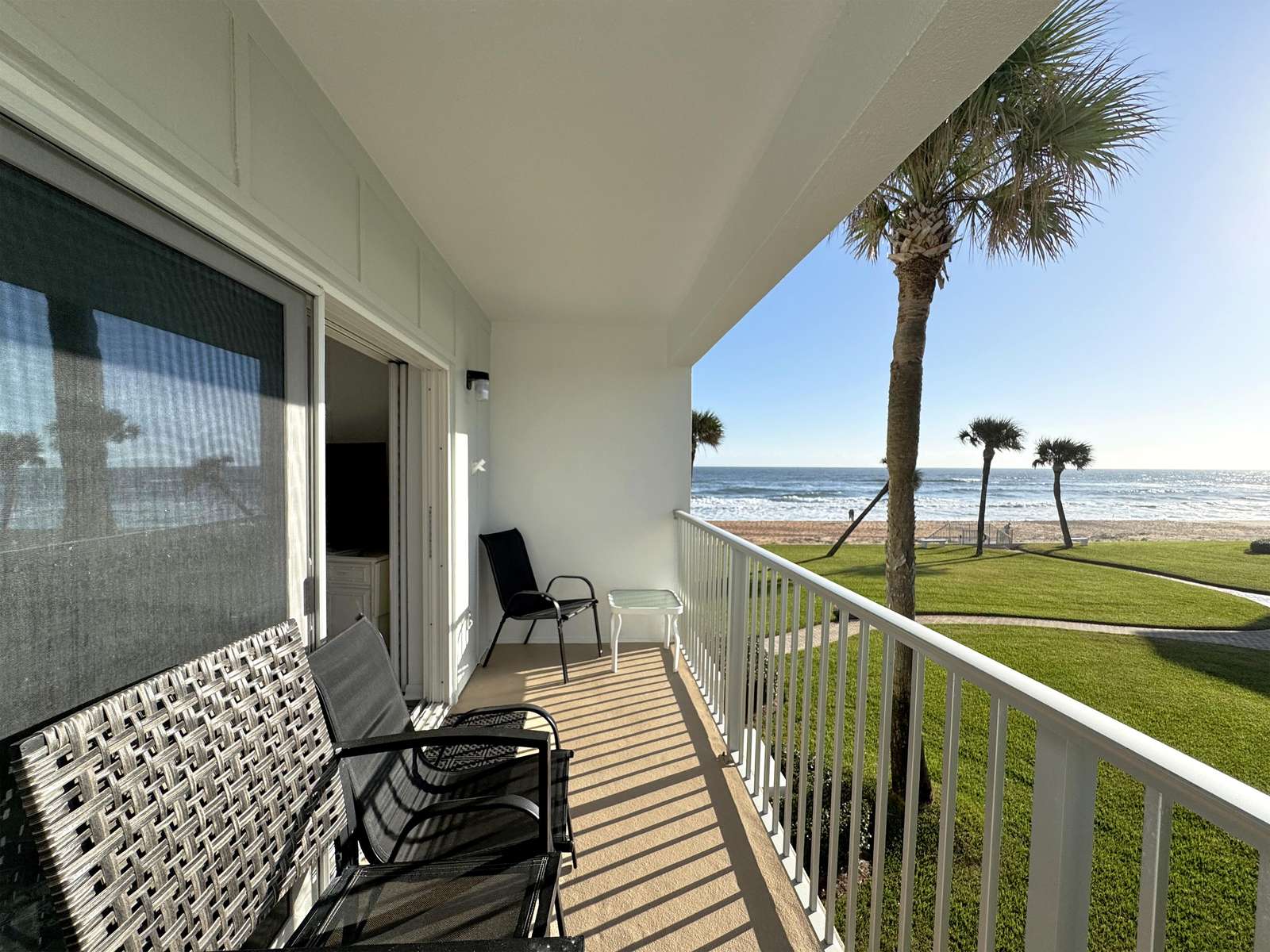 Oceanfront balcony with cozy seating and stunning views - property