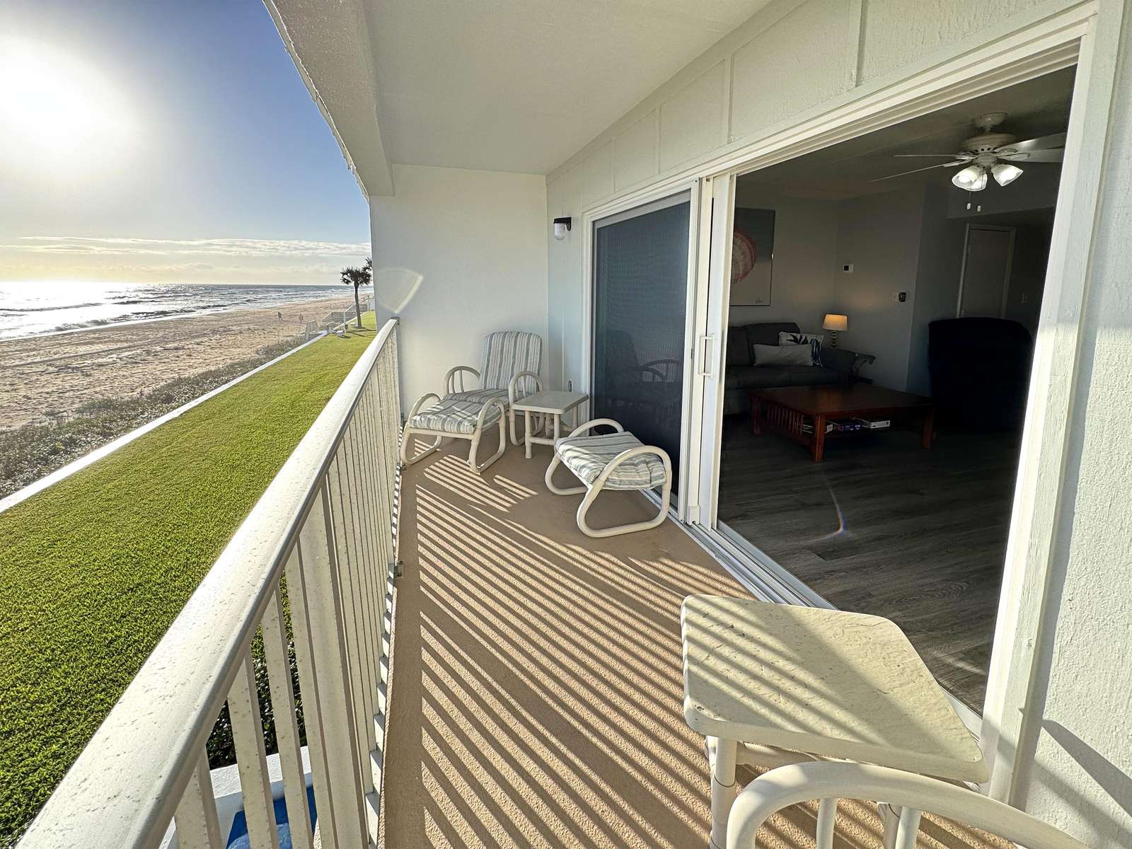 Oceanfront balcony with stunning sunrise views and cozy seating - property