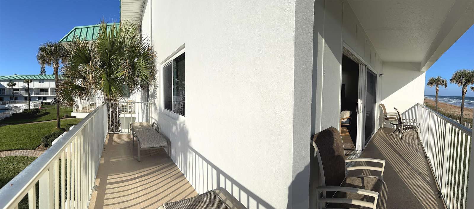 Sunny balcony retreat with cozy seating and scenic views - property