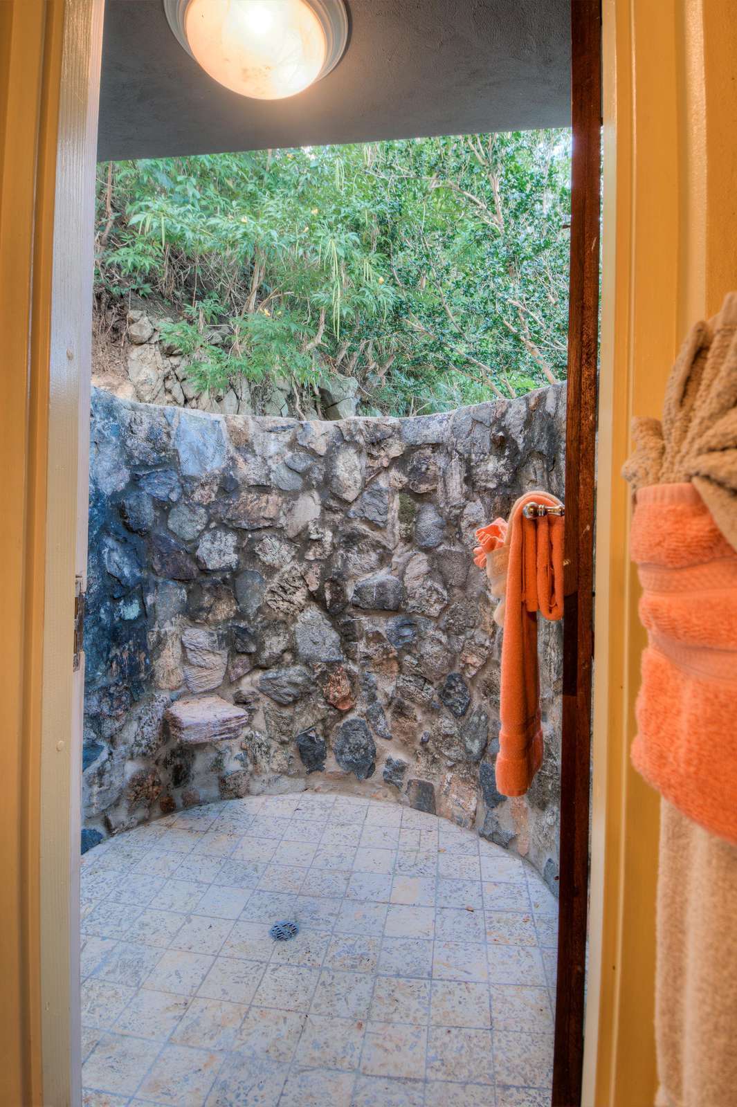 Secluded outdoor shower surrounded by natural stone walls