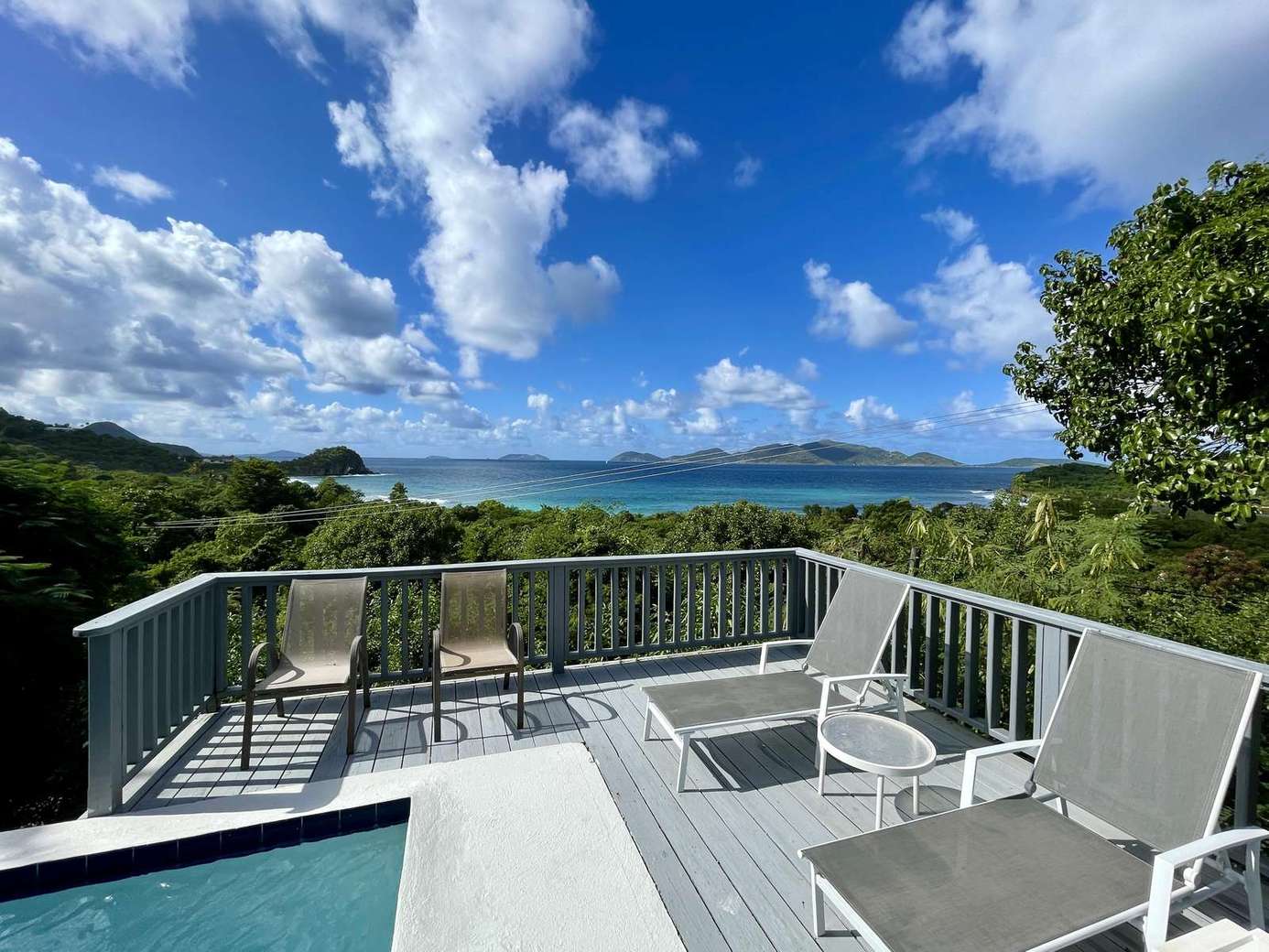 Sun-drenched deck with panoramic mountain and ocean views