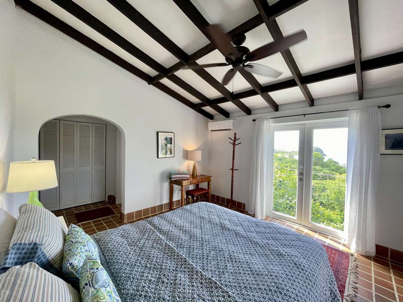 Bright bedroom with vaulted ceiling and scenic window views