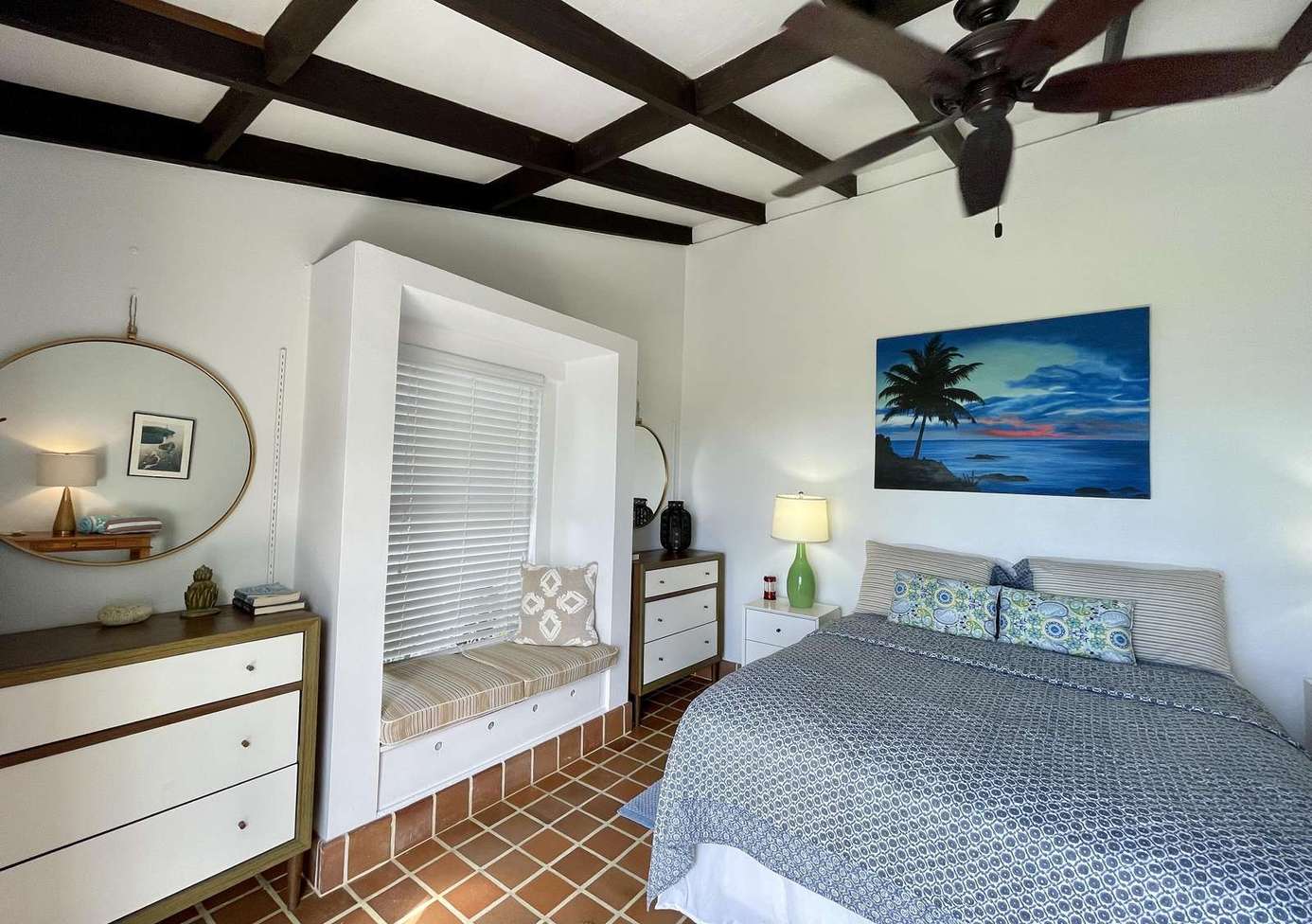 Cozy bedroom with rustic beams and serene ocean artwork