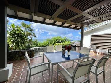 Spacious covered patio with ocean views and dining area