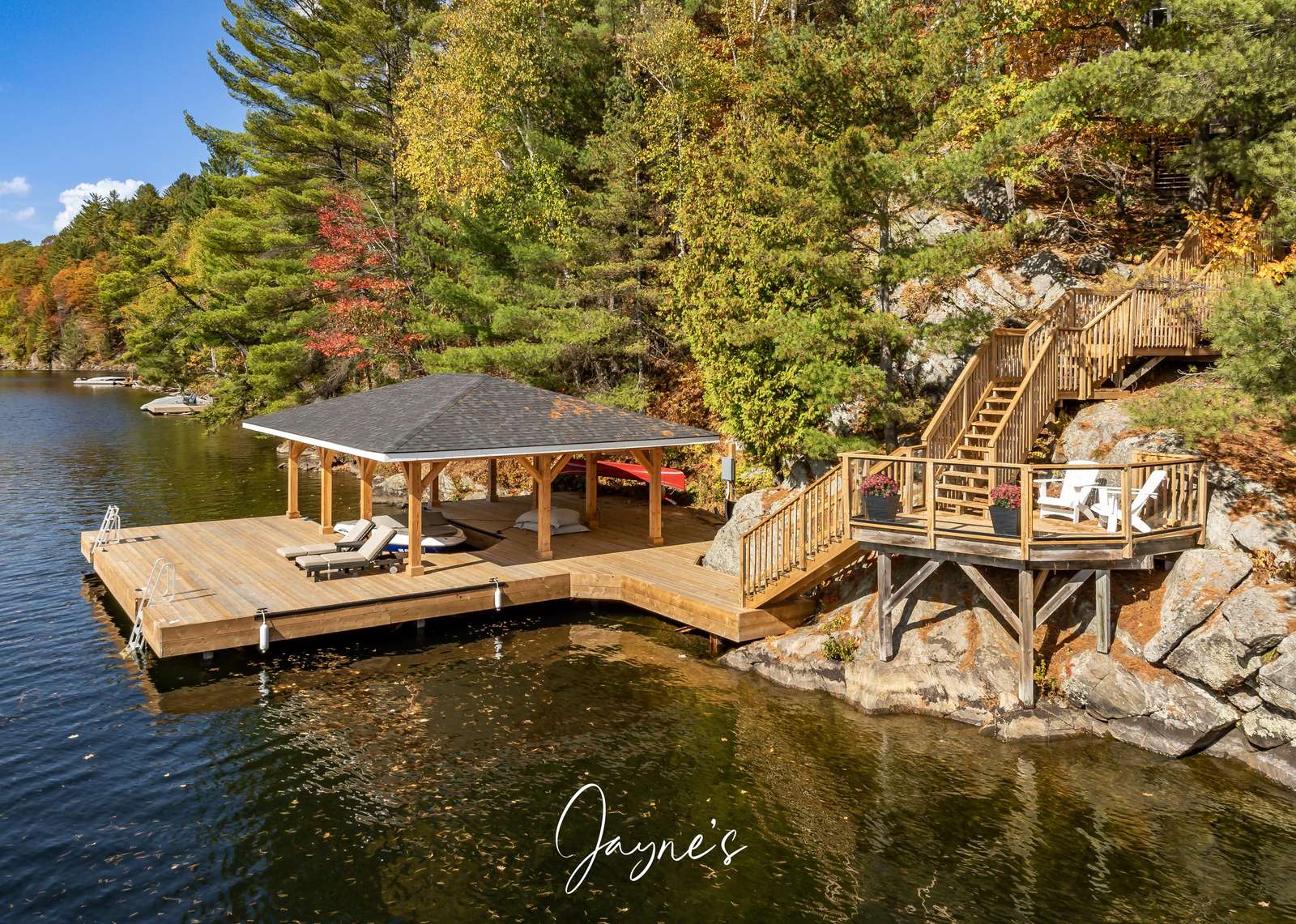 Secluded lakeside dock with cozy covered seating and stunning nature views - property