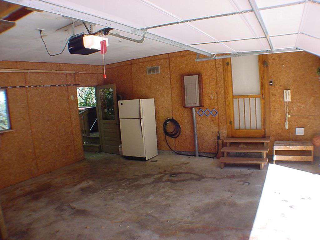 Garage with extra refrigerator for storage.