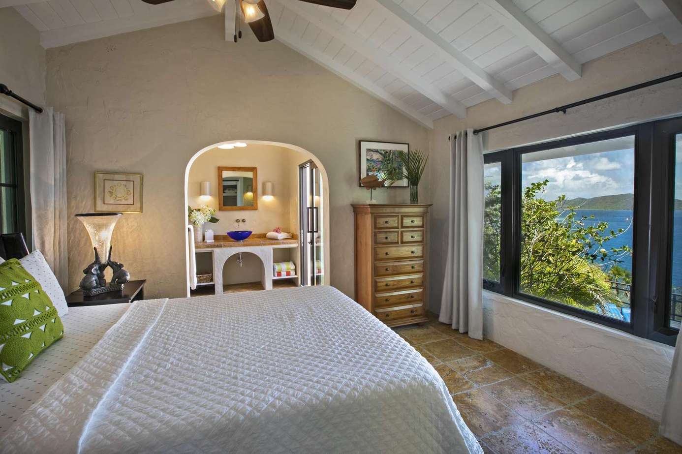 Cozy bedroom with vaulted ceilings and scenic window views