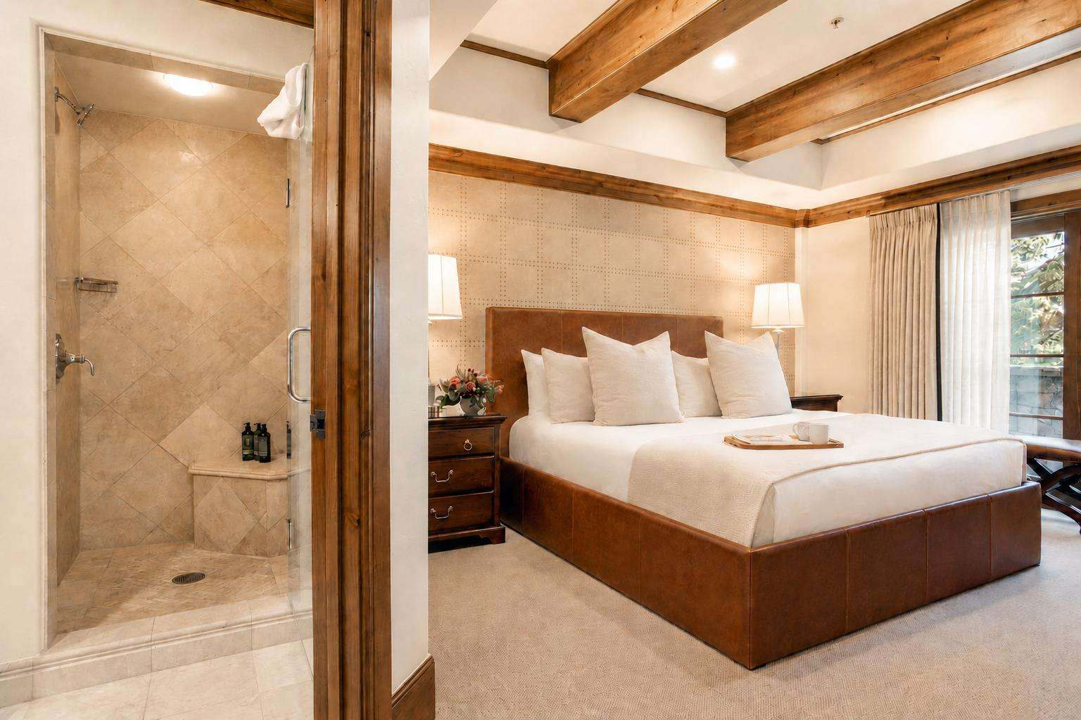 A luxurious hotel room with a large bed, a shower, and a window