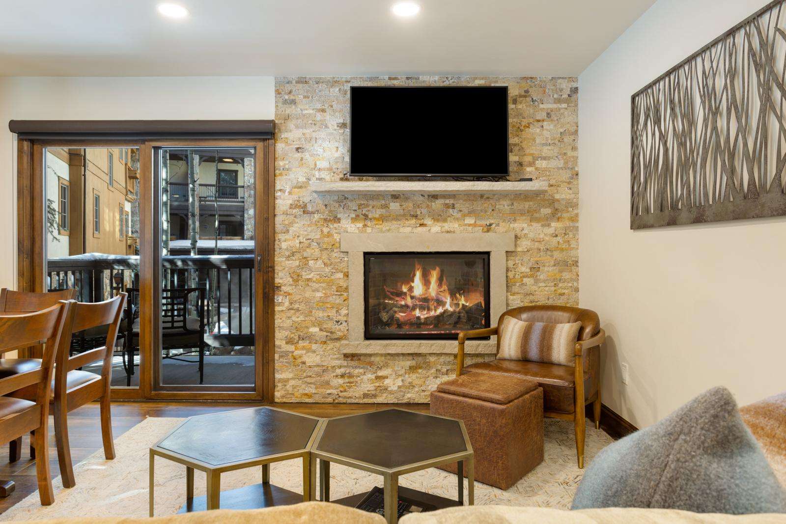 A cozy lounge area with a fireplace, TV, and comfortable seating.