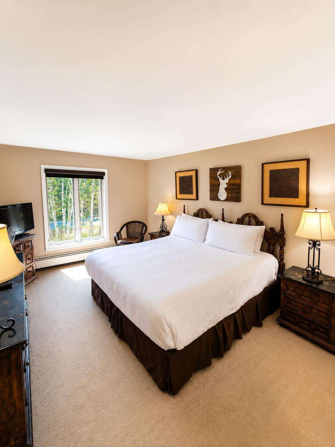 A hotel room with a large bed, two nightstands, and a window.